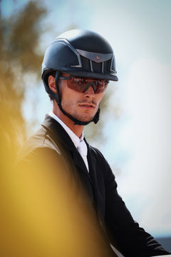Person wearing a helmet and sunglasses with a blurred background